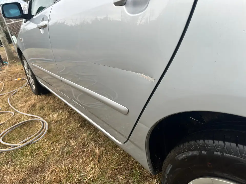 Close-up of the scuff in the paint on the rear driver's side door