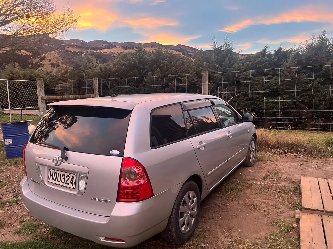 The silver 2006 Toyota Corolla Fielder wagon at sunset, with the Central Otago hills behind