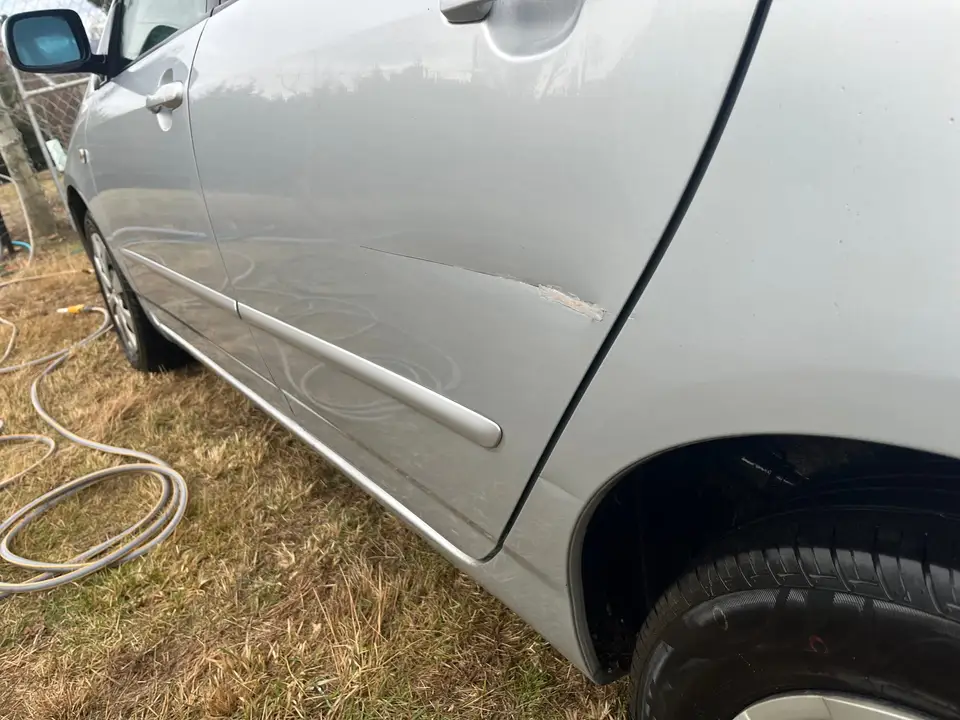 Close-up of the scuff in the paint on the rear left door