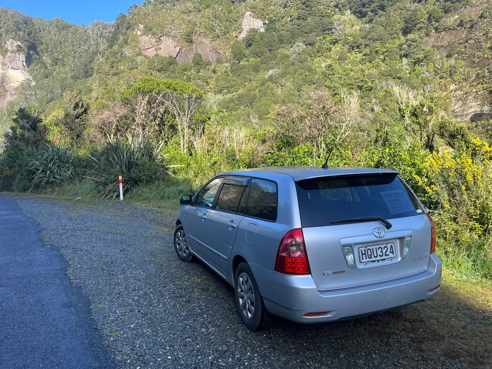 Parked on a gravel pull-off below the cliffs