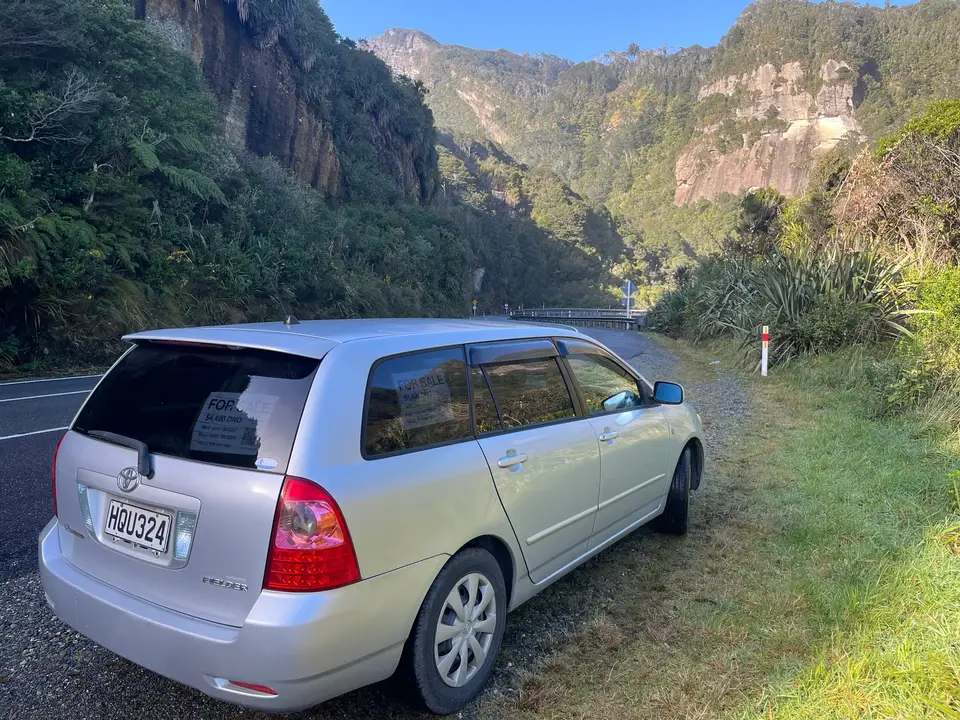 Parked below bush-clad limestone cliffs