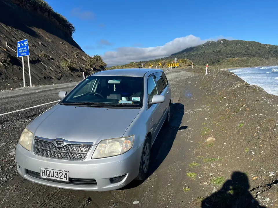 Parked on a coastal road beside the surf
