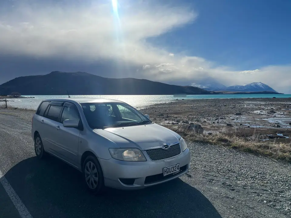 Parked by a lake shore with mountains beyond