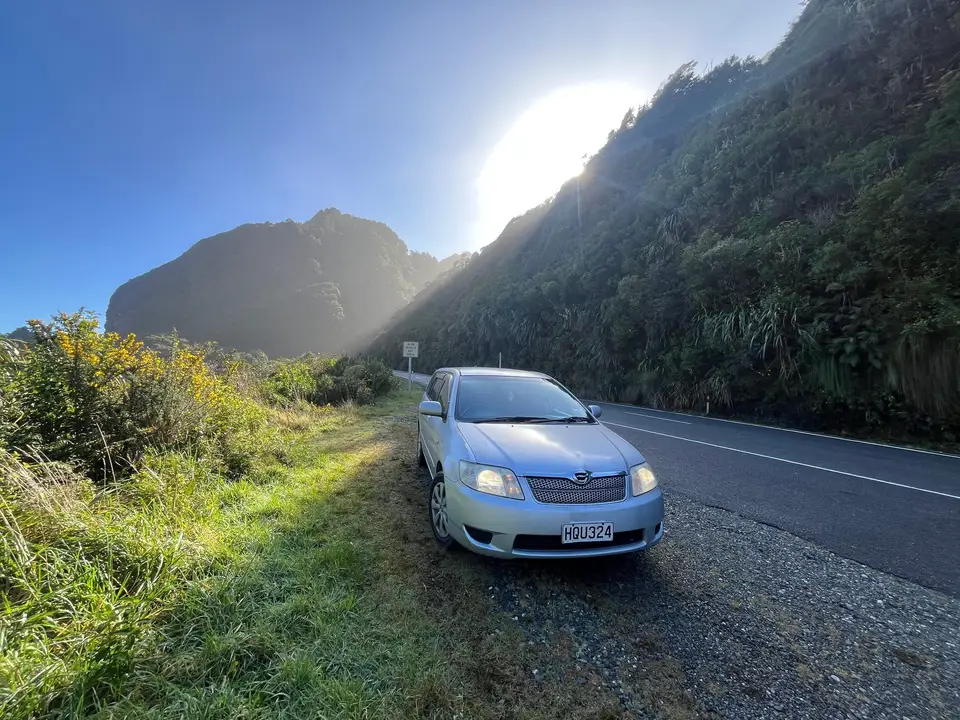 Parked on a coastal road below a headland