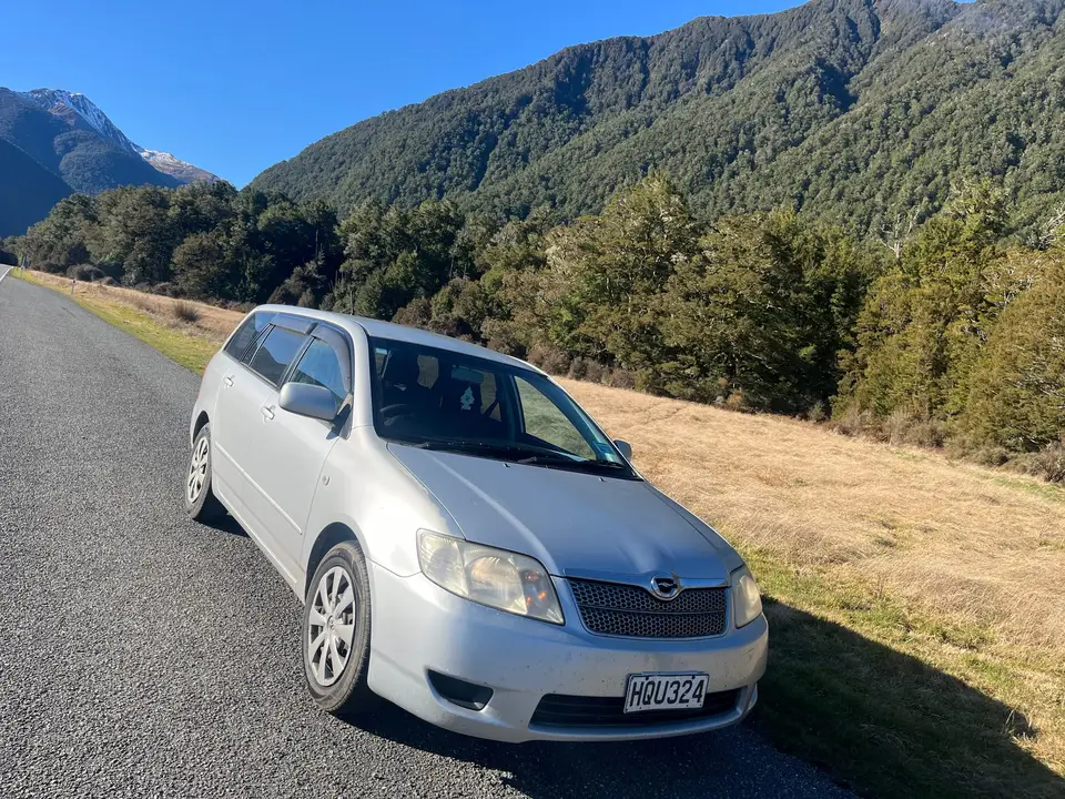 Parked on the highway below bush-clad mountains